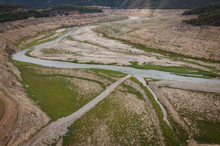 An aerial view of the Rialb reservoir in Lleida, one of the largest in Catalonia, is at just over 8% of its capacity due to the drought in Rialb, Spain on May 30, 2023. The drought in Spain is affecting water resources very drastically due to climate change and poor water management. Photo courtesy Adri Salido/Anadolu Agency via Getty Images